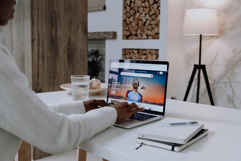 Person in White Long Sleeve Shirt Using Macbook Pro